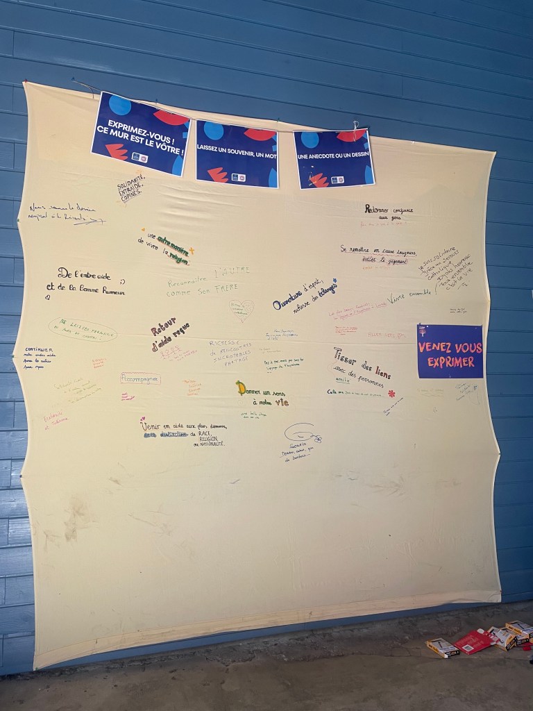 Mur d'expression avec des messages écrits à la main, invitant les gens à partager des souvenirs et des anecdotes.
